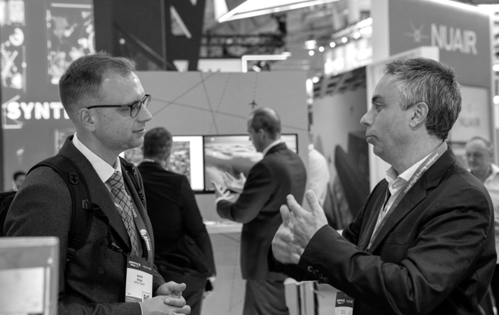 AirNav Systems representatives speaking at an aviation industry event.